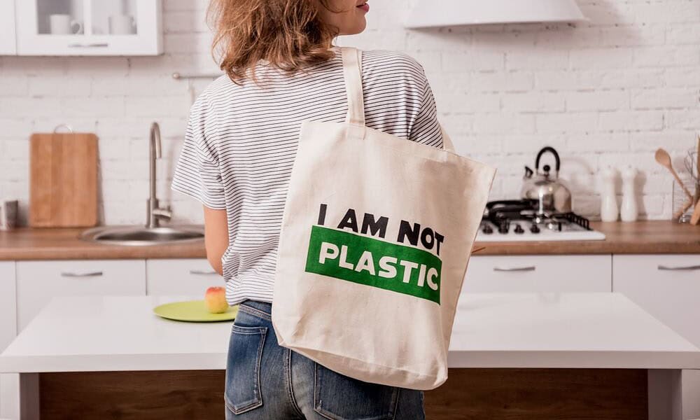 ผู้หญิงถือกระเป๋าผ้า CSR สกรีนข้อความ I AM NOT PLASTIC