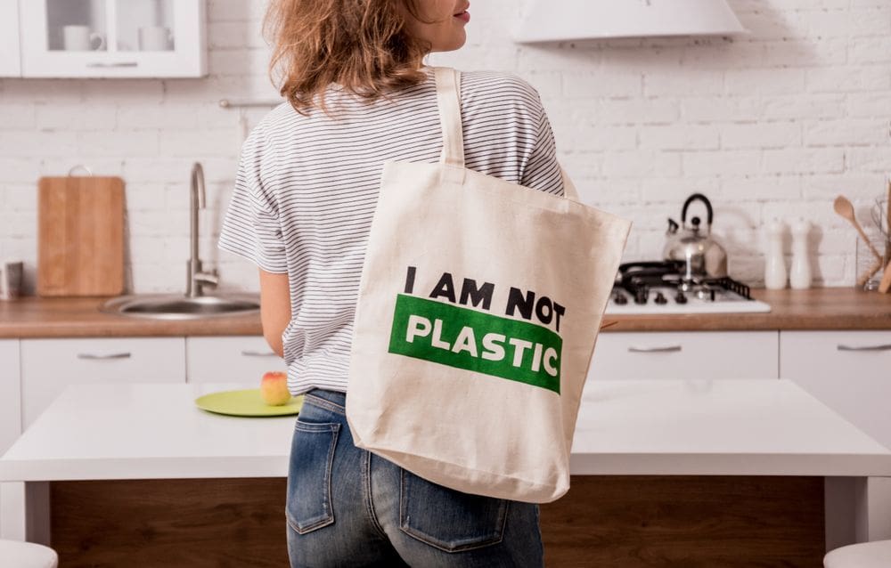 ผู้หญิงถือกระเป๋าผ้า CSR สกรีนข้อความ I AM NOT PLASTIC